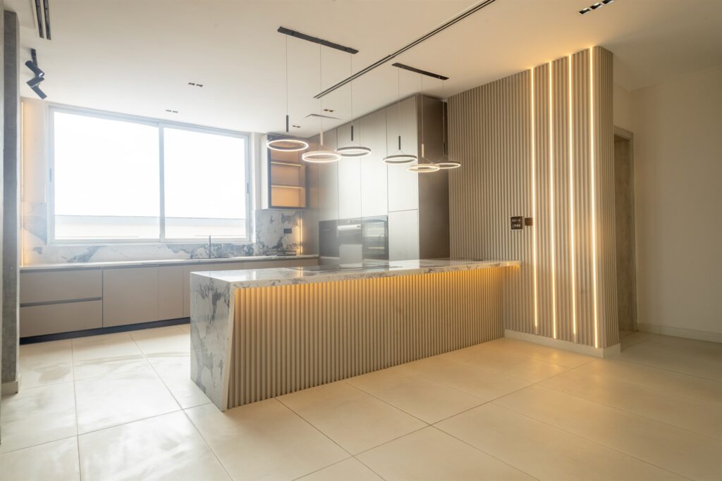 Brum Height 6: Kitchen island with a stone top and circular pendant lights